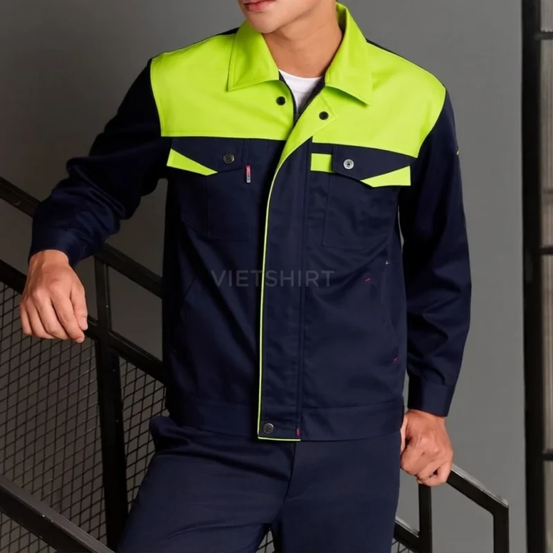 Người mẫu kỹ sư mặc bộ đồ bảo hộ lao động màu xanh lá chuối đứng cạnh cầu thang