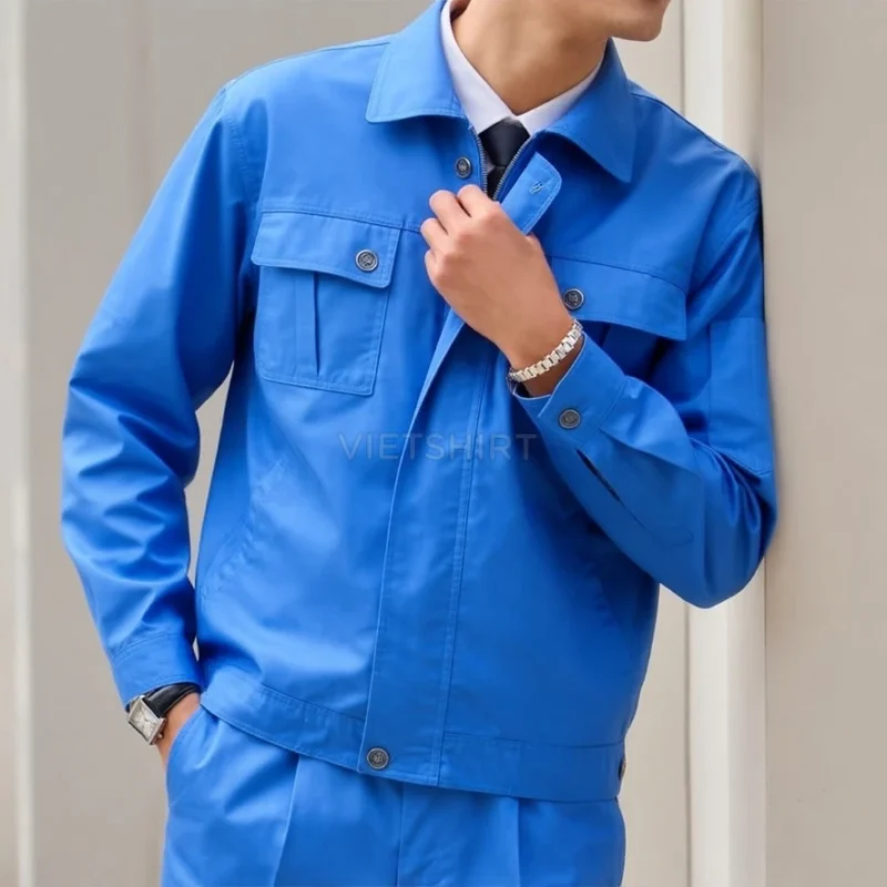 Kỹ sư nam mặc bộ đồ bảo hộ lao động đứng cạnh tường